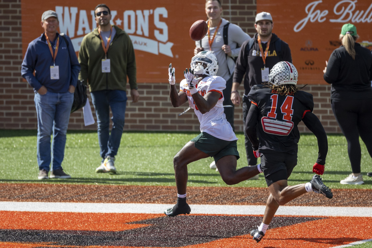 Jan 31, 2023; Mobile, AL, USA; National wide receiver Jayden Reed of Michigan State (1) makes a catch in the end zone ahead of National defensive back Ronnie Hickman of Ohio State (14) during the first day of Senior Bowl week at Hancock Whitney Stadium in Mobile.